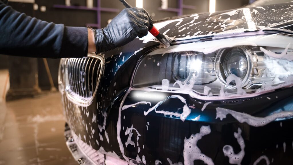 Person Washing Side of Car Using Brush